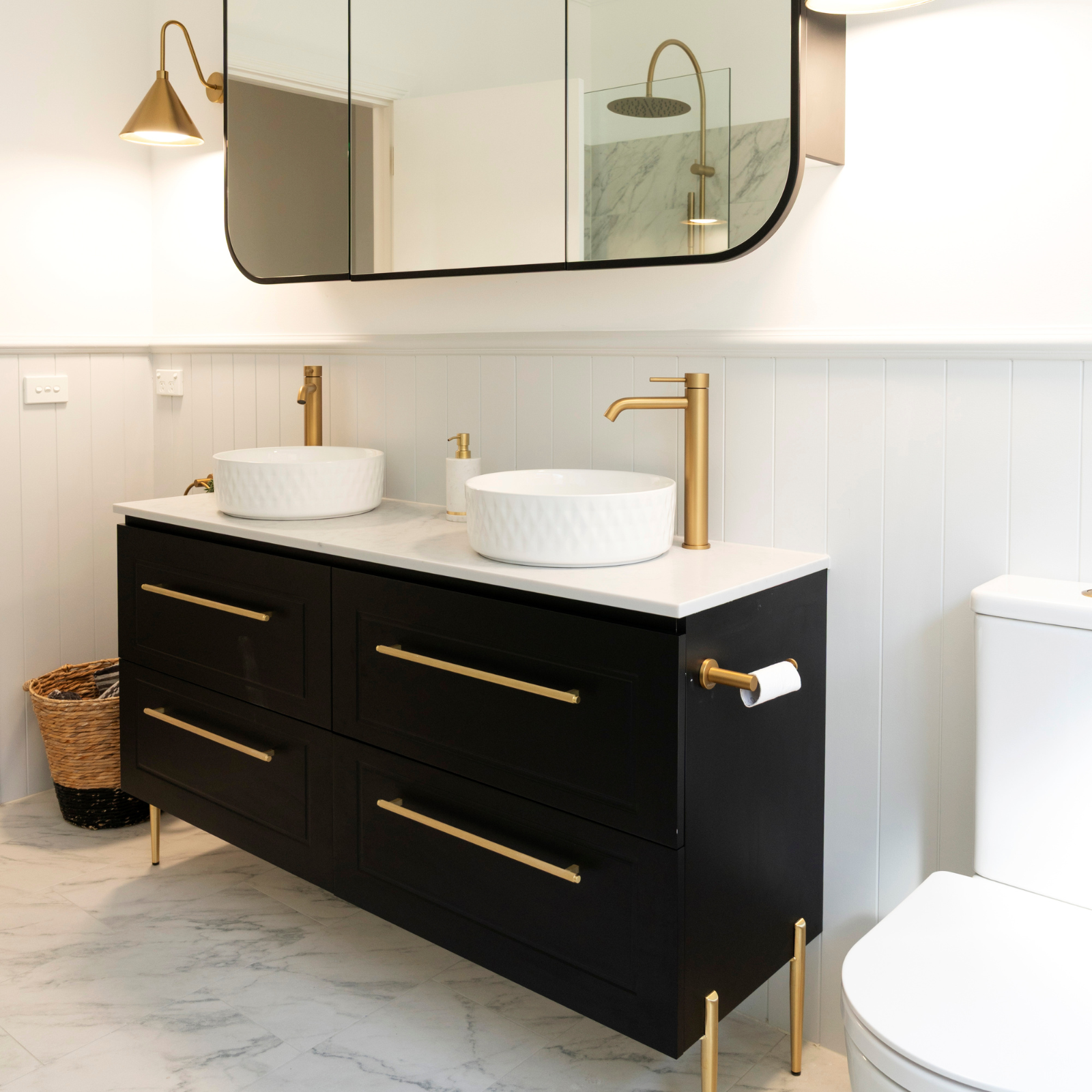 Classic modern bathroom design with royal blue shaker vanity, brushed bras tapware and marble tiles.